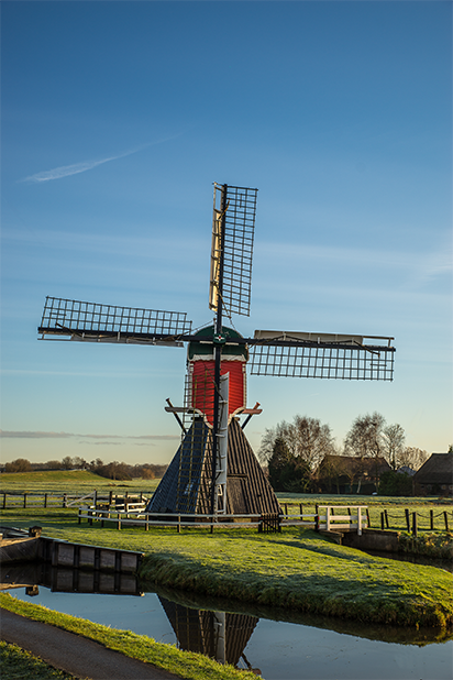 Traditional windmill on a green field